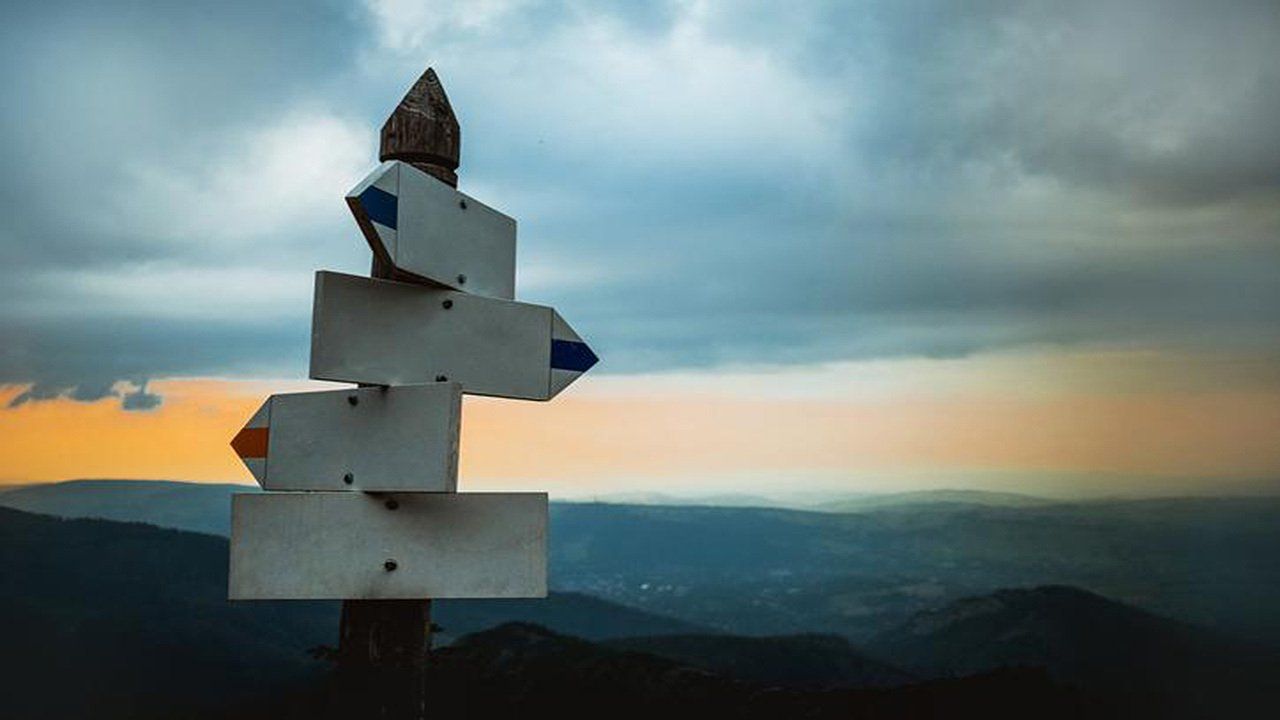 A wooden signpost with arrows pointing in different directions.