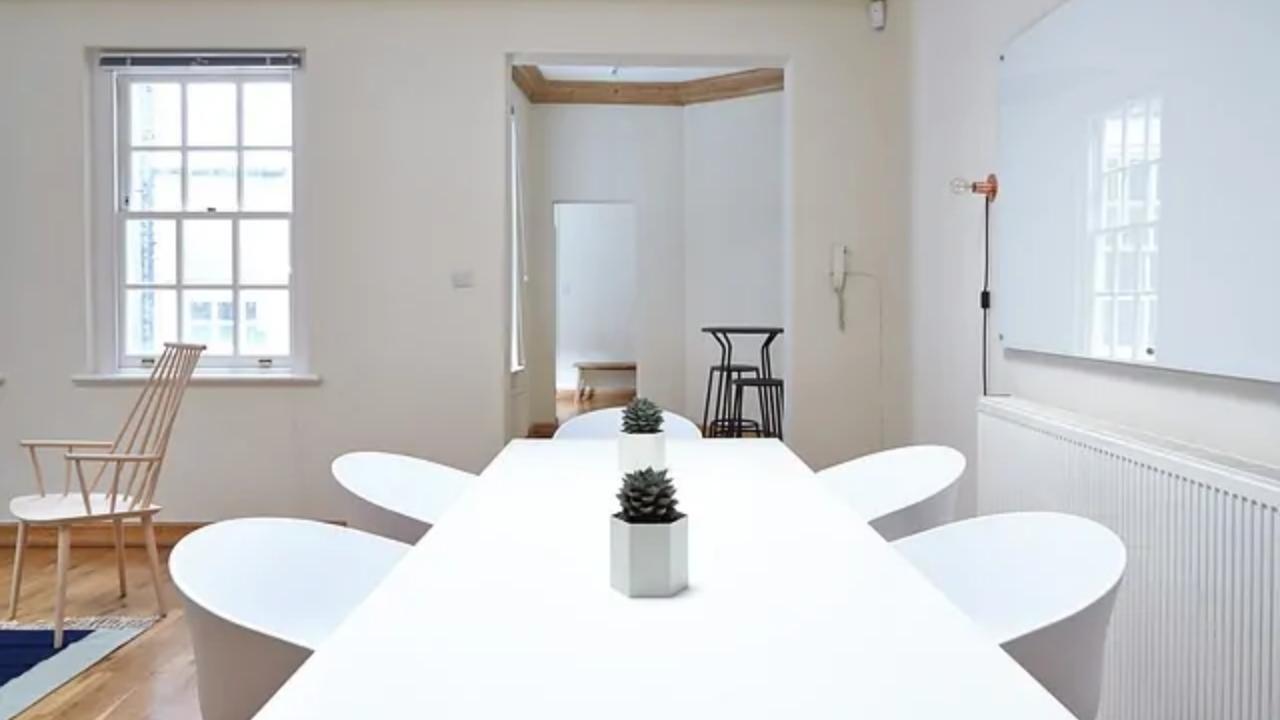A conference room with a long white table and chairs.