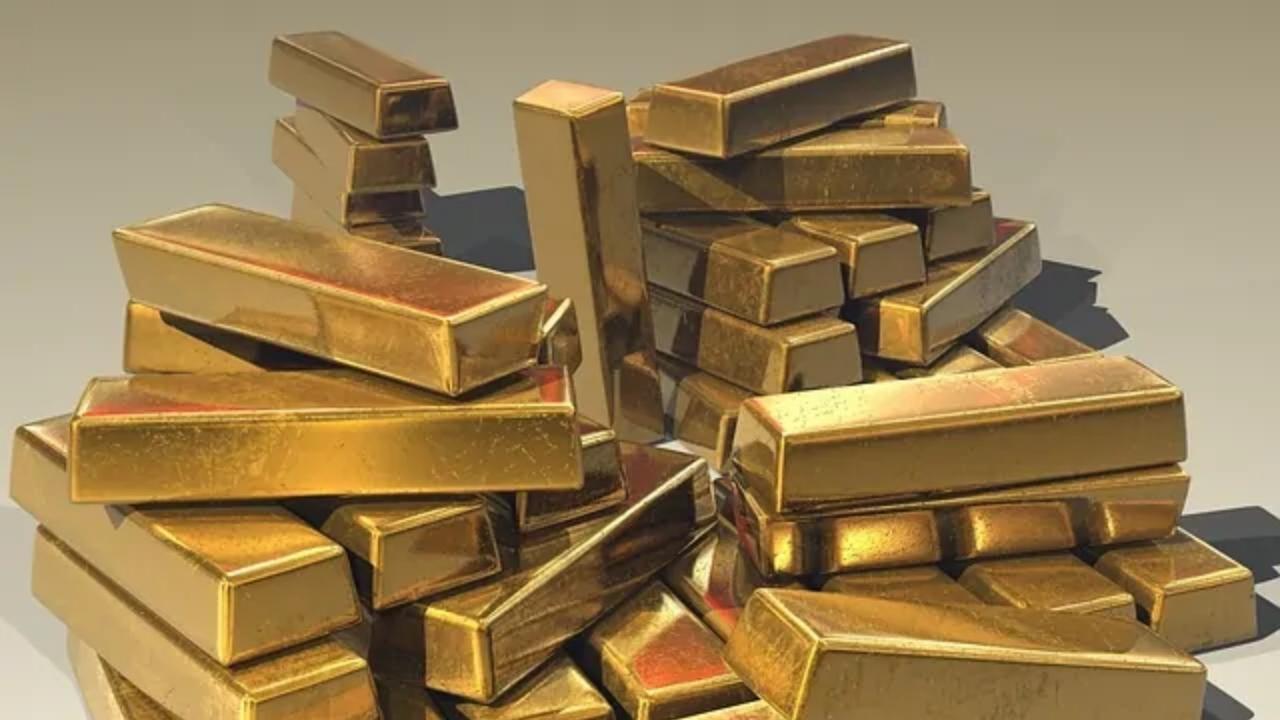 A pile of gold bars stacked on top of each other on a table.
