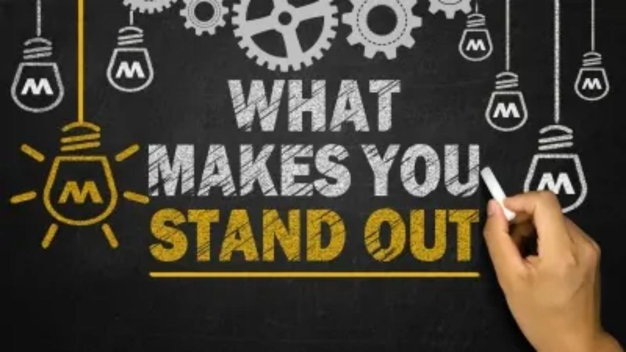 A person is writing on a blackboard that says what makes you stand out