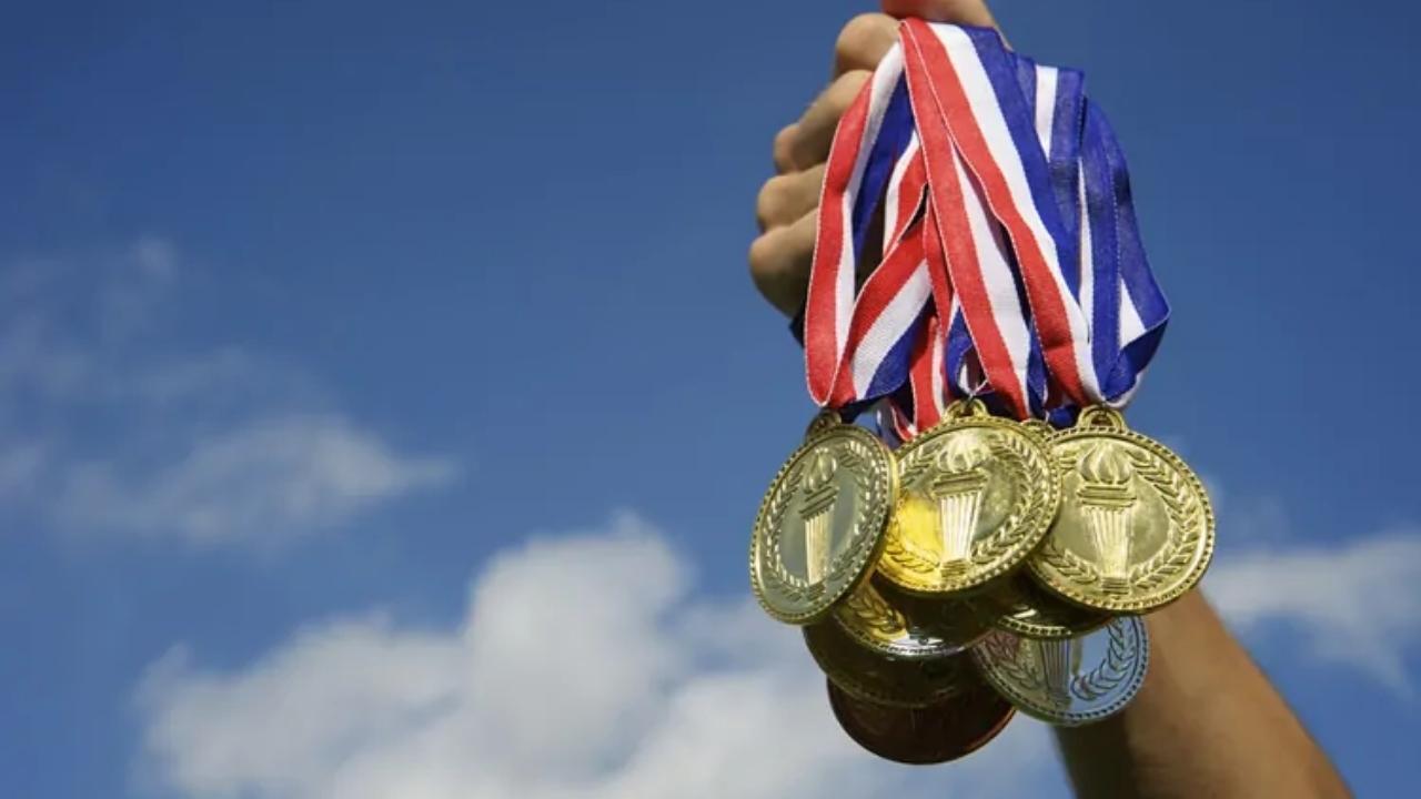 A person is holding a bunch of medals in their hand
