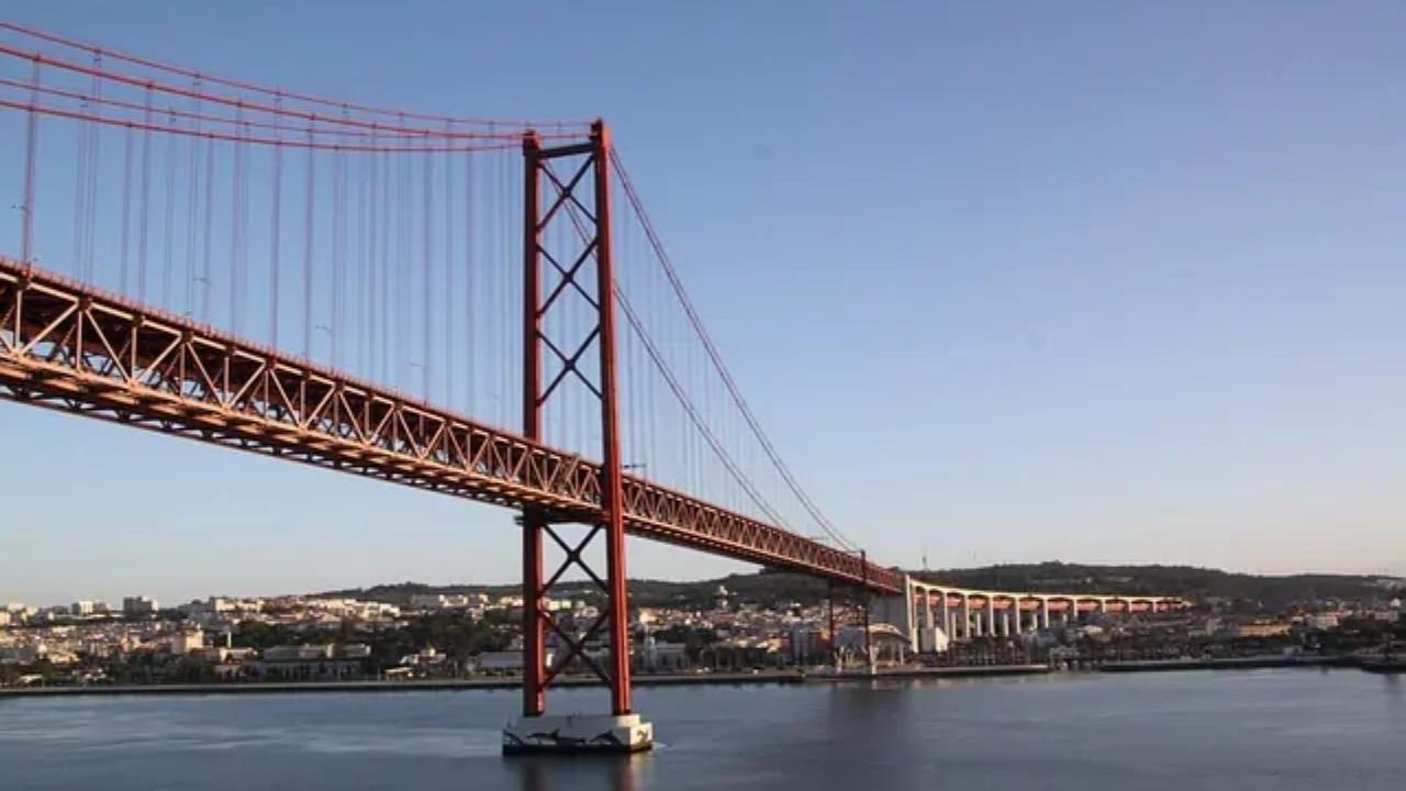 A bridge over a body of water with a city in the background