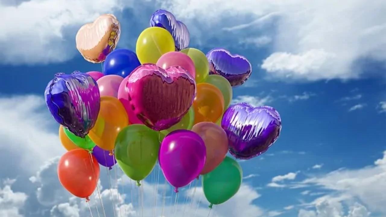 A bunch of colorful balloons are flying in the sky.