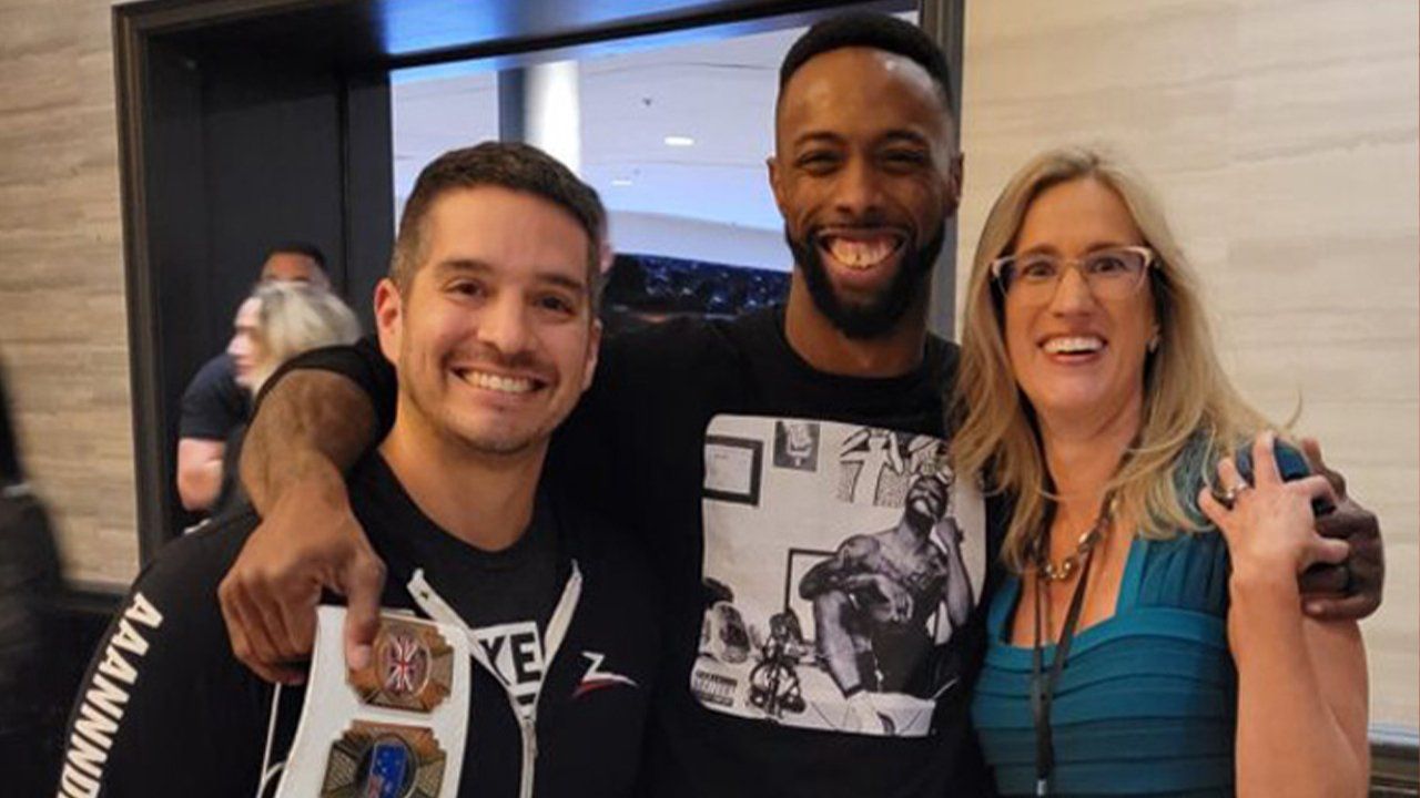 A man and two women are posing for a picture together.