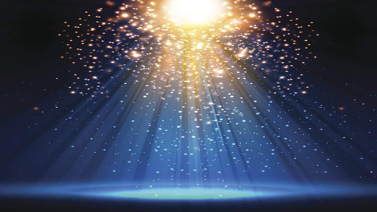 A spotlight is shining on a stage with sparks coming out of it.
