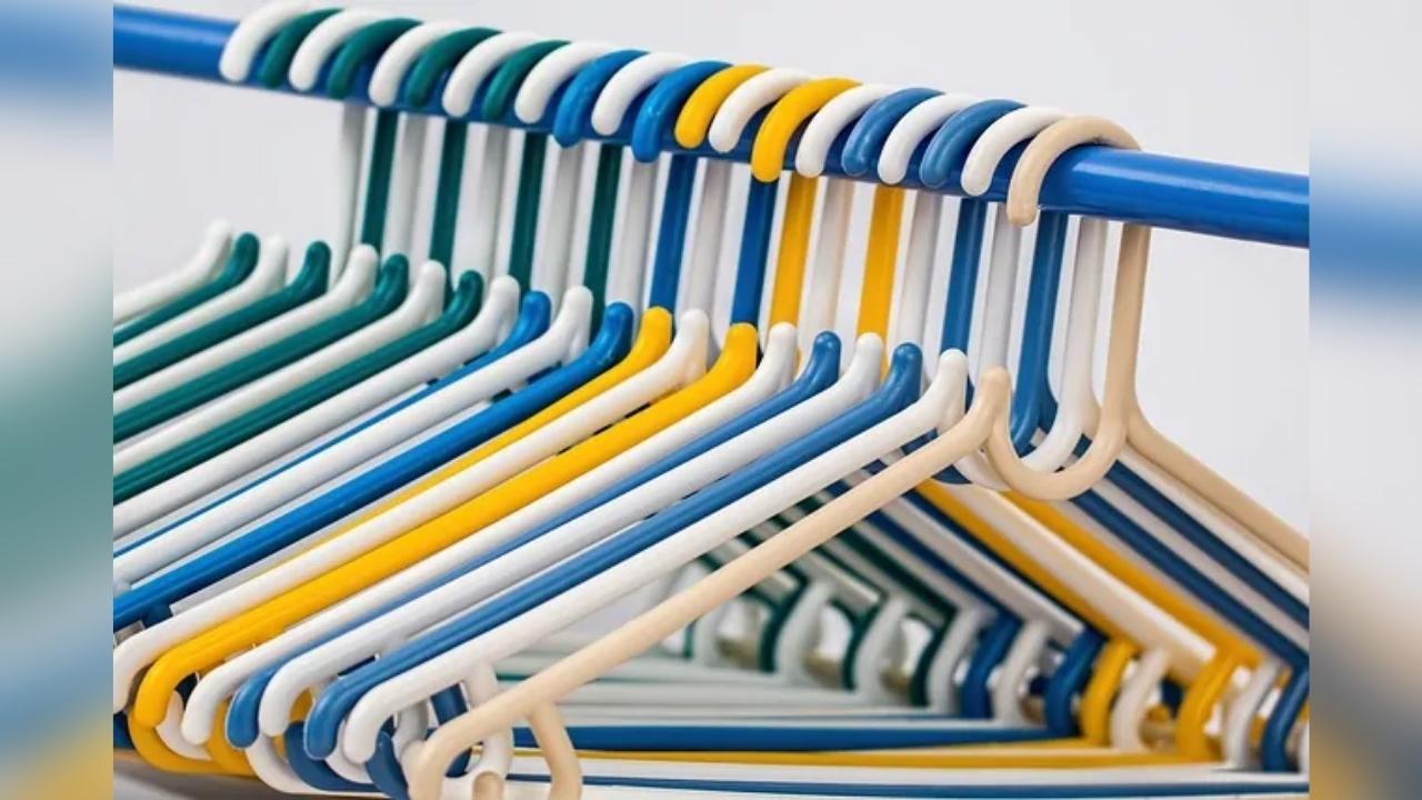 A bunch of colorful plastic hangers hanging on a rack