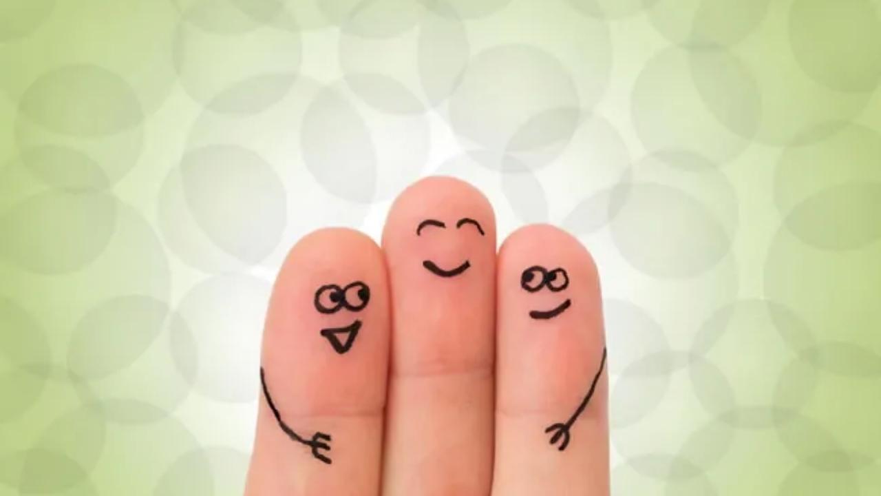 Three fingers with smiley faces drawn on them