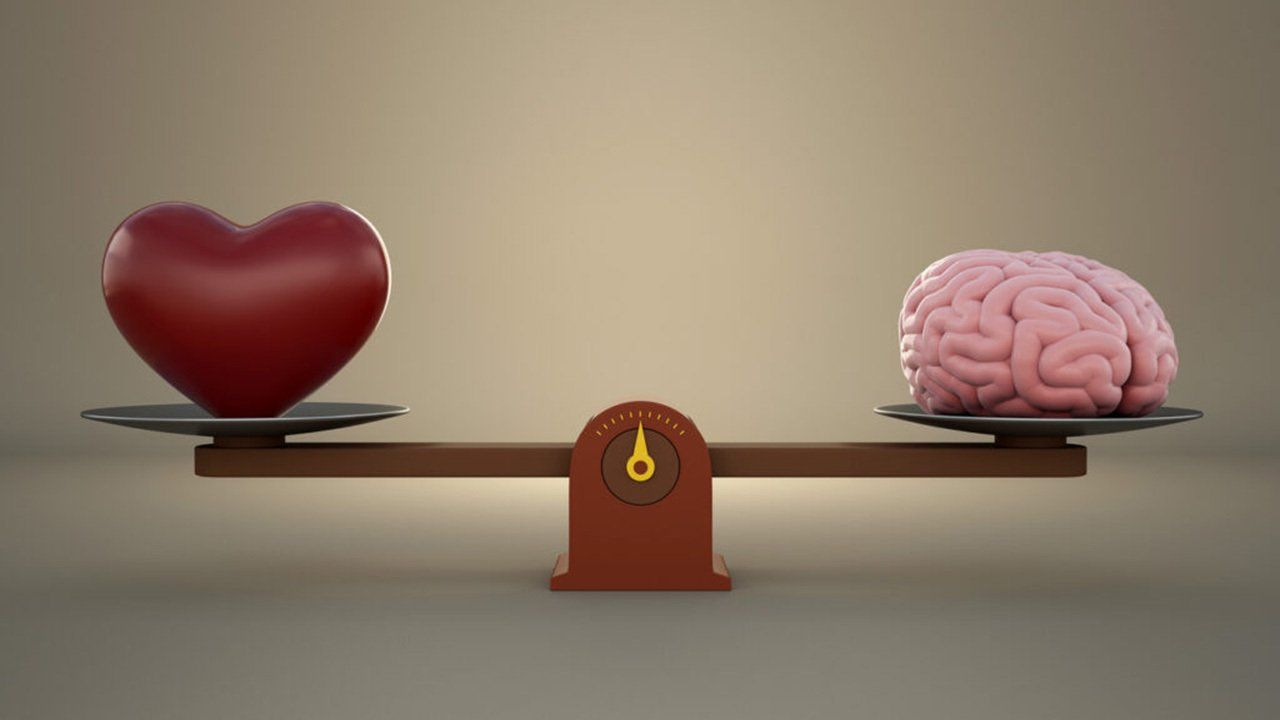 A heart and a brain are on a scale.