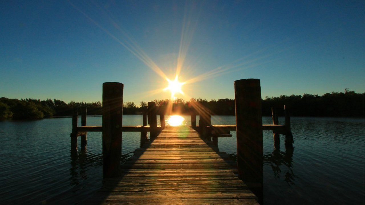 The sun is shining brightly over a dock