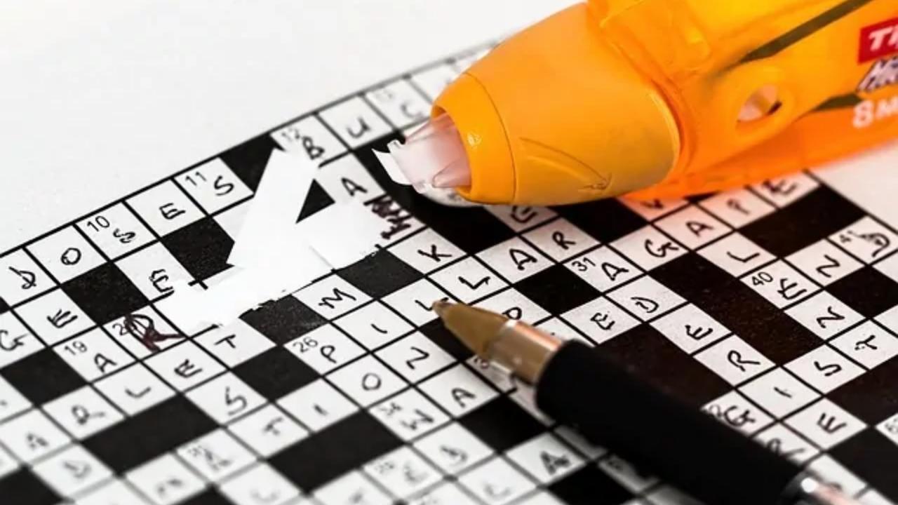 A crossword puzzle with a pen and a glue stick