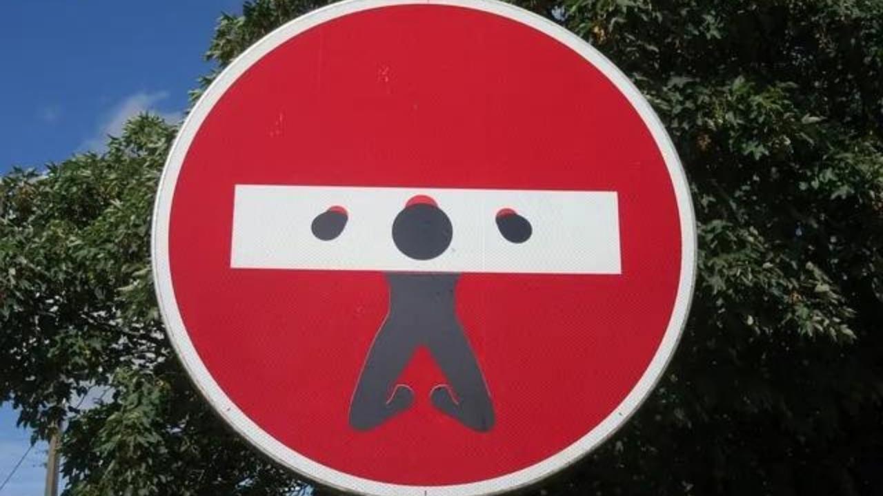 A red and white sign with a silhouette of a man on it