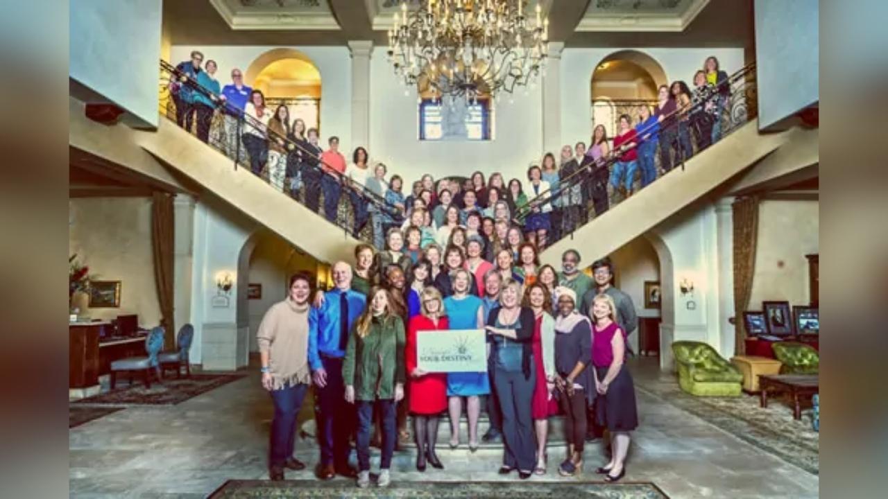 A large group of people are posing for a picture in a large room.