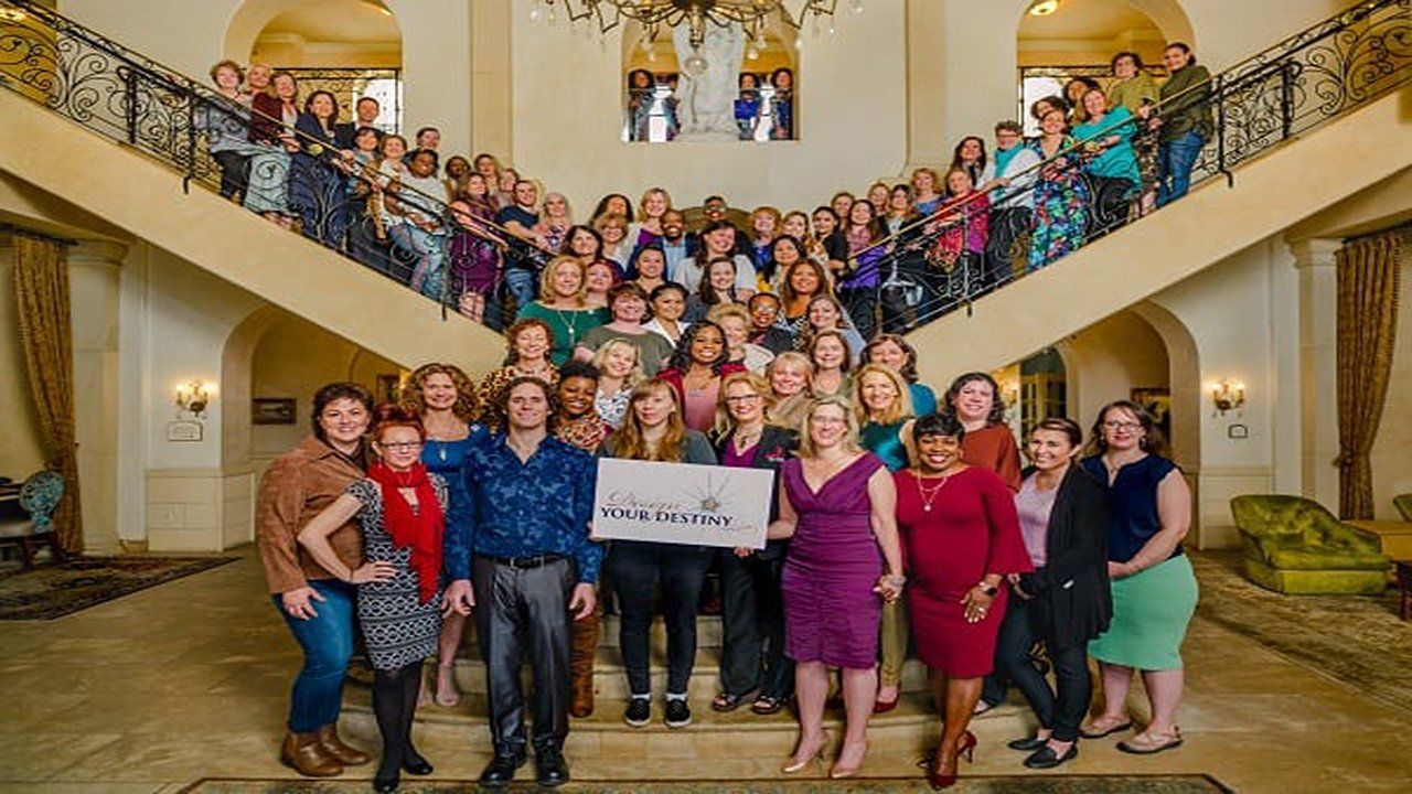 A large group of people are posing for a picture in front of a staircase.