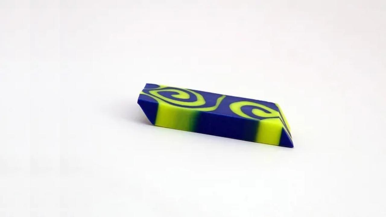 A blue and yellow eraser with swirls on it