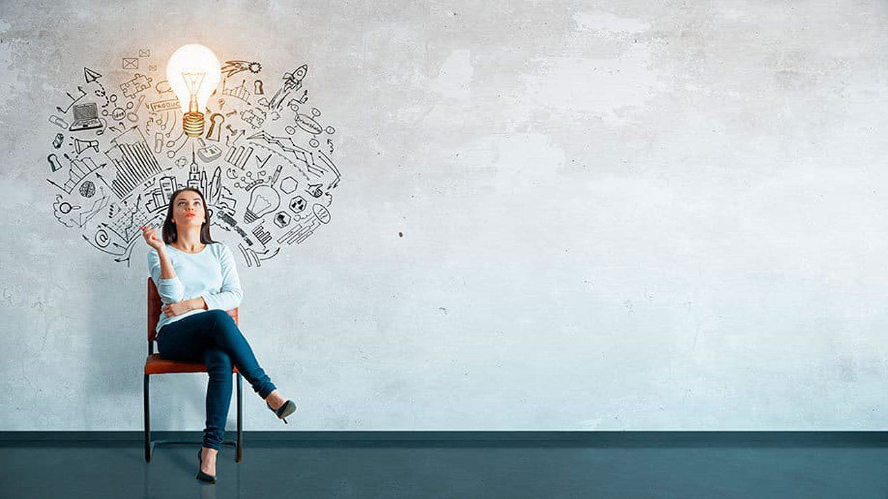 A woman is sitting in a chair with a light bulb coming out of her head.