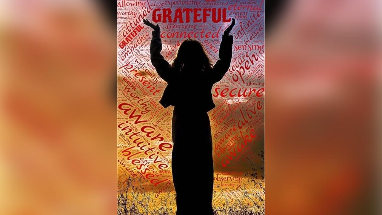 A silhouette of a woman with her arms in the air.