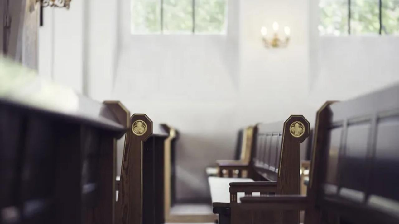 A row of wooden benches in an empty church.