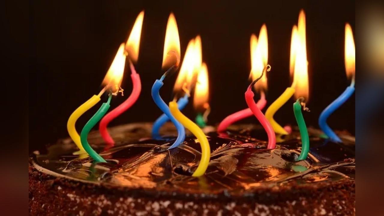 A birthday cake with many lit candles on it