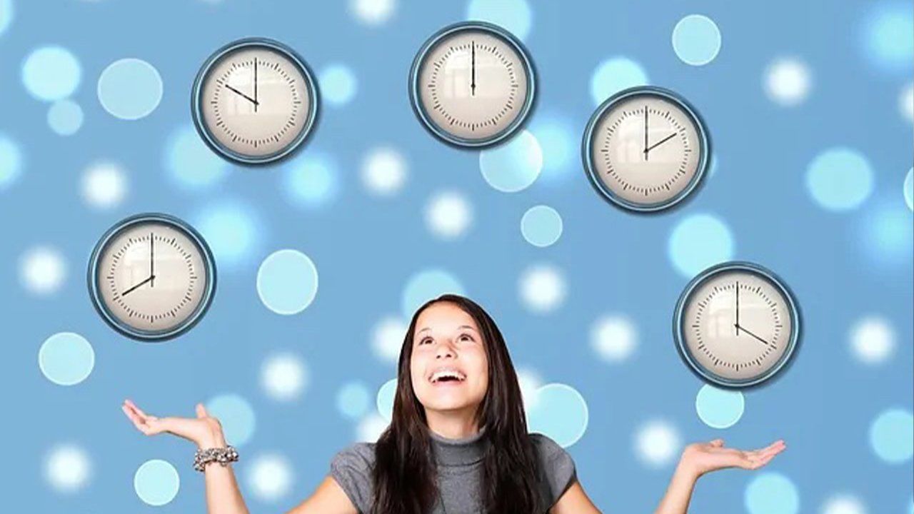 A woman is juggling clocks on a blue background.