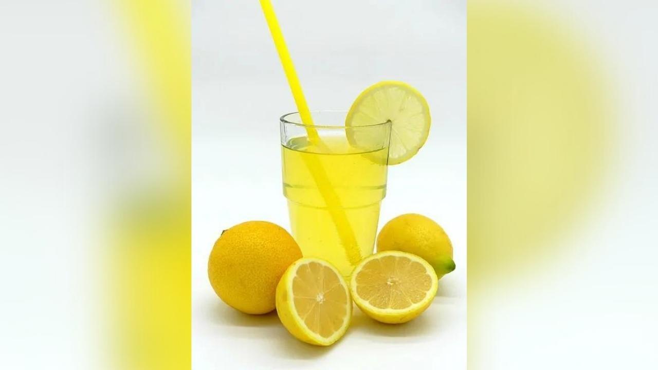 A glass of lemon juice with a yellow straw