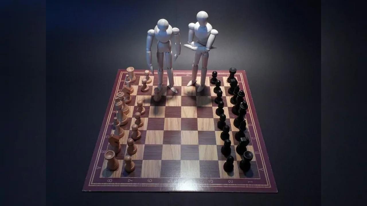 Two mannequins are standing on top of a chess board.