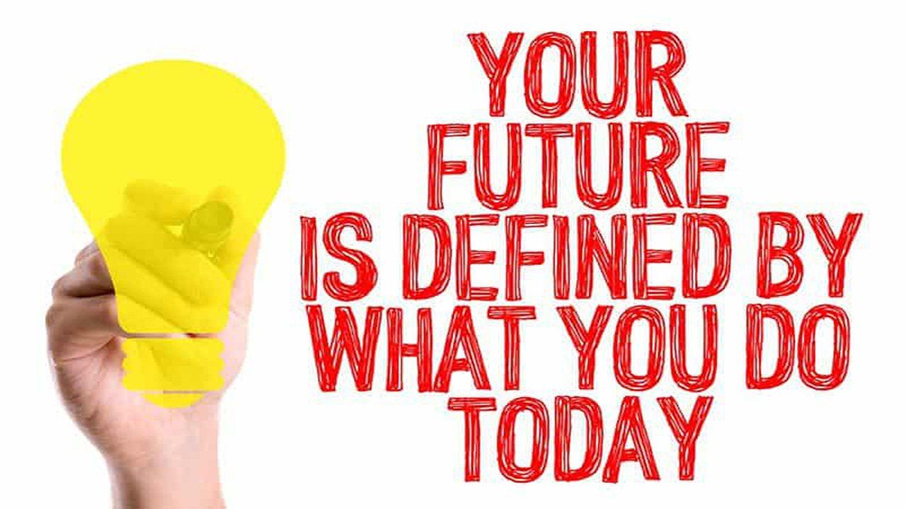 A hand is holding a light bulb with the words `` your future is defined by what you do today '' written on it.