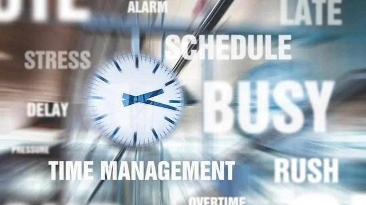 A clock is surrounded by words such as schedule busy and time management