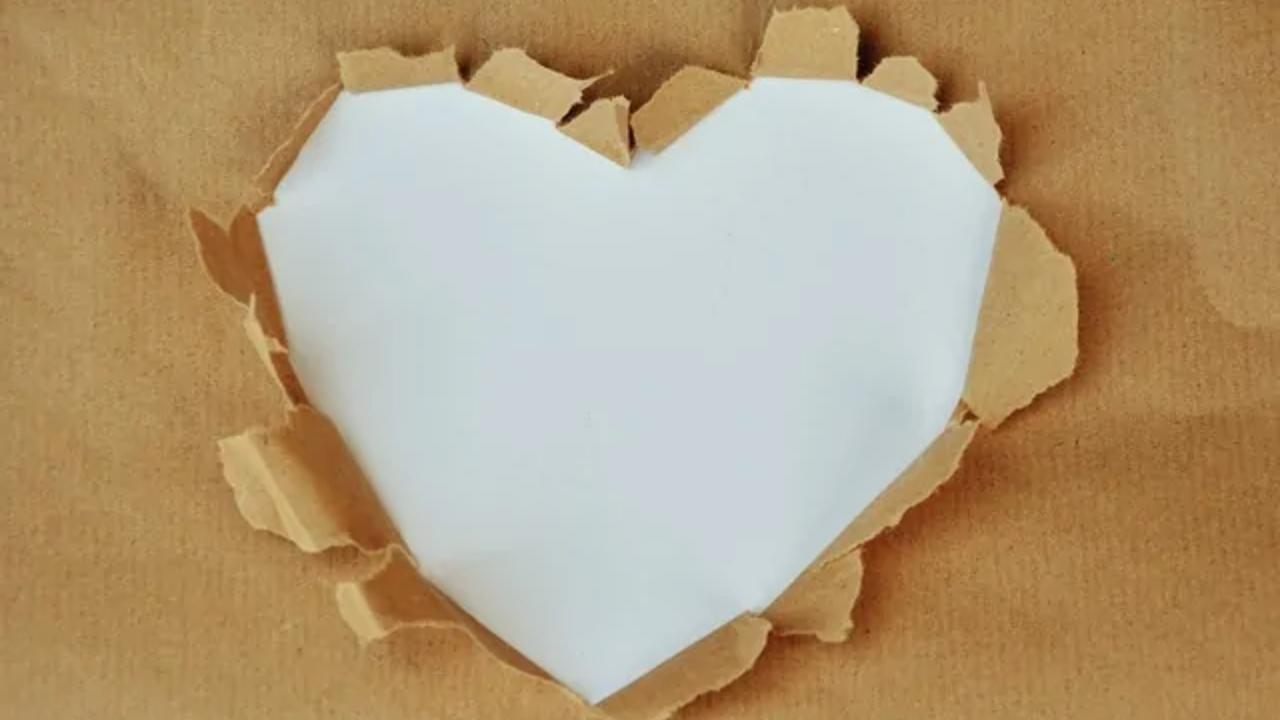A heart shaped hole in a piece of brown paper