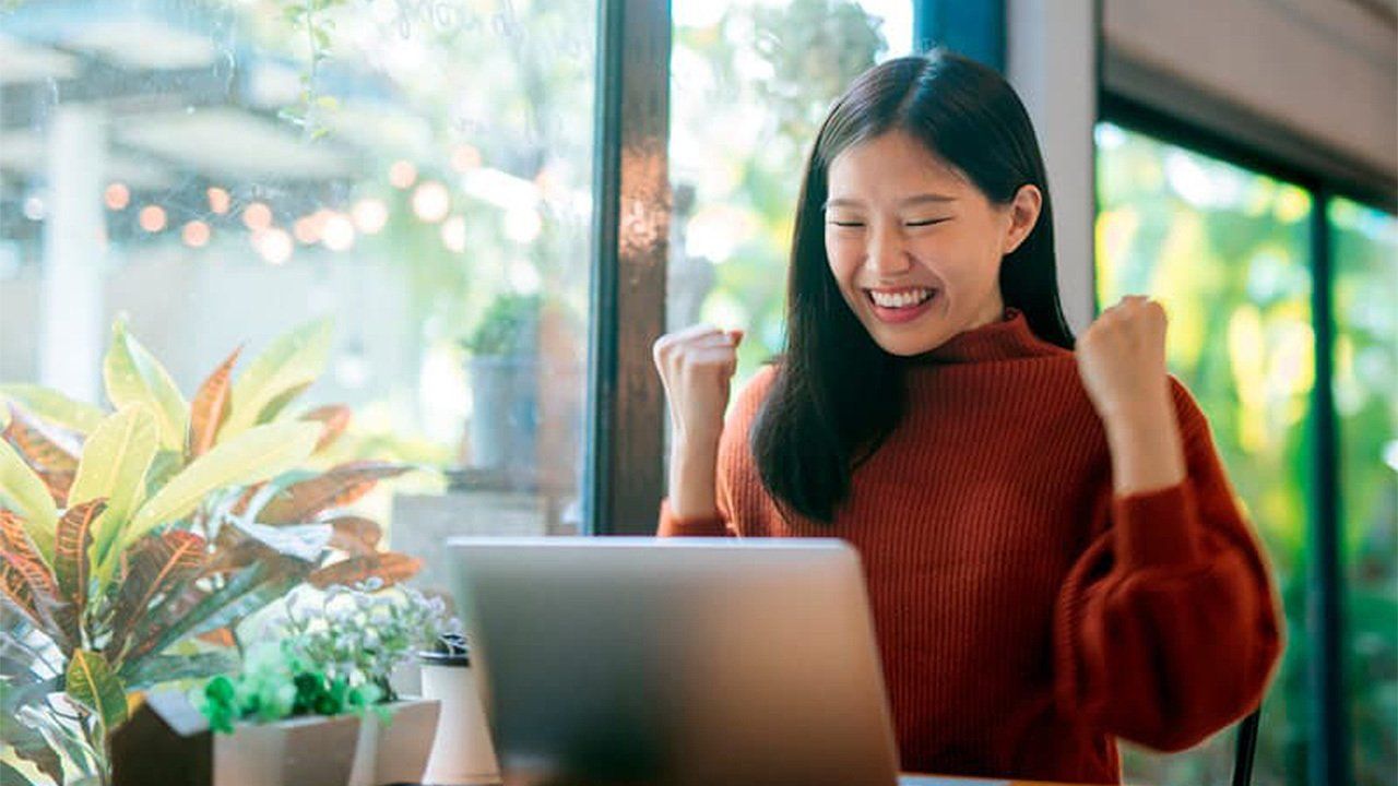 A woman is sitting in front of a laptop computer.