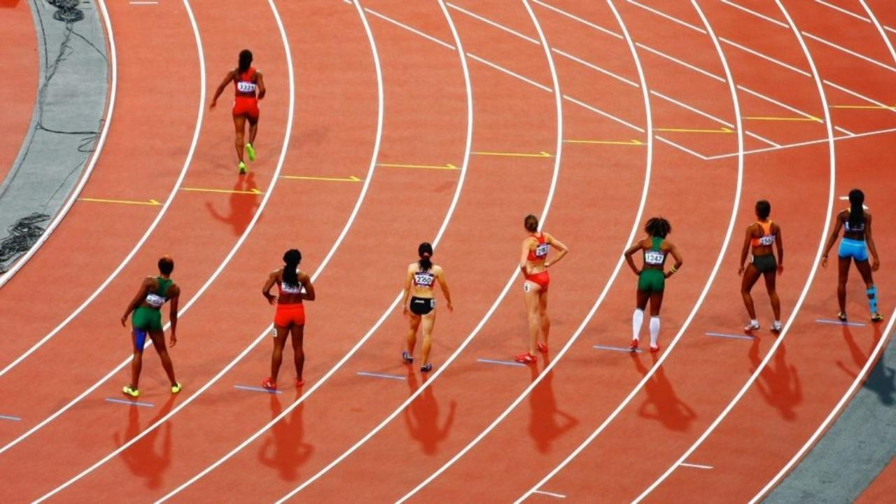 A group of female athletes are running on a track