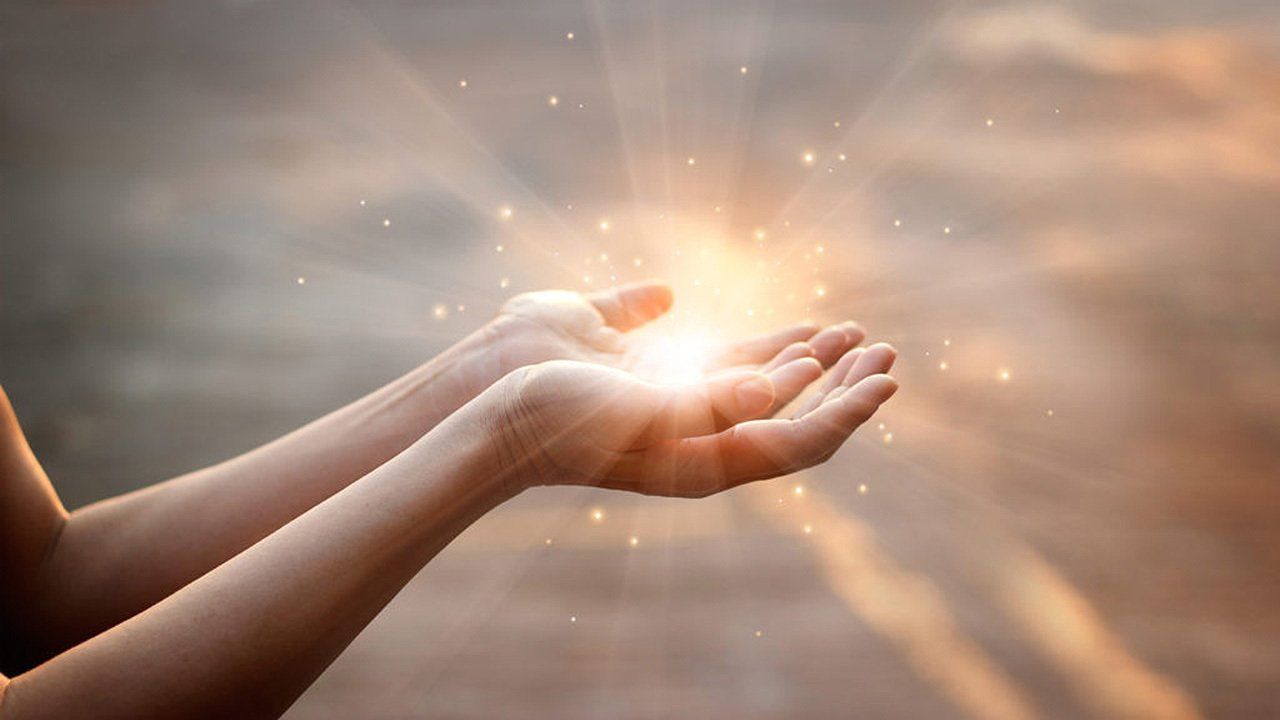 A person is holding a light in their hands.