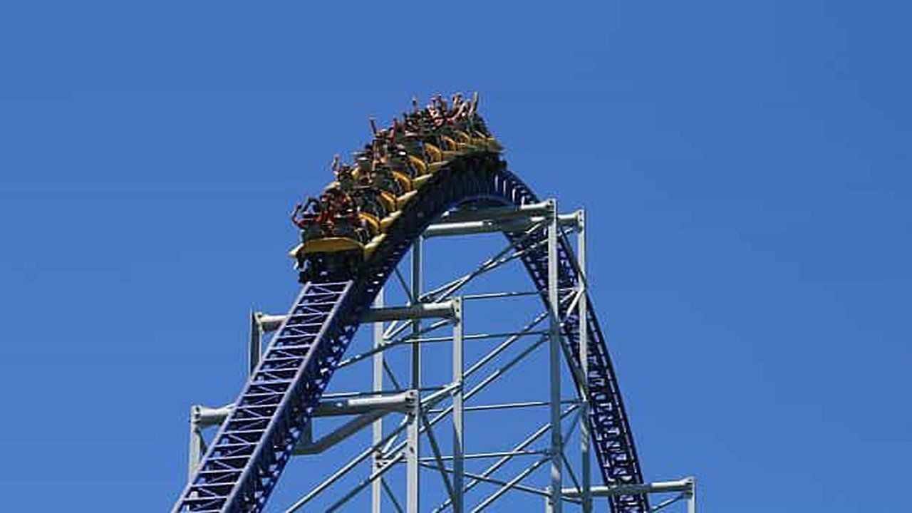 A roller coaster with a blue sky in the background.