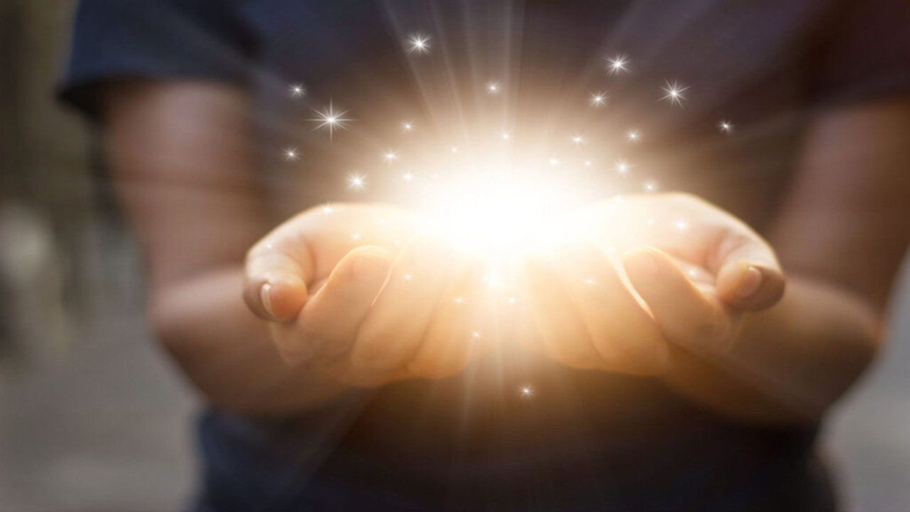 A person is holding a light in their hands.