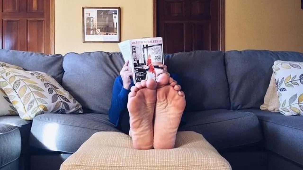A person is sitting on a couch reading a magazine.