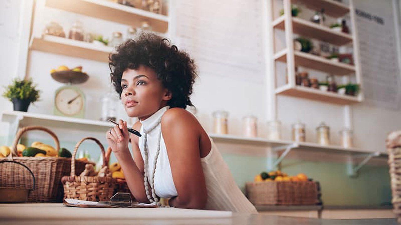 A woman is sitting at a table in a kitchen.