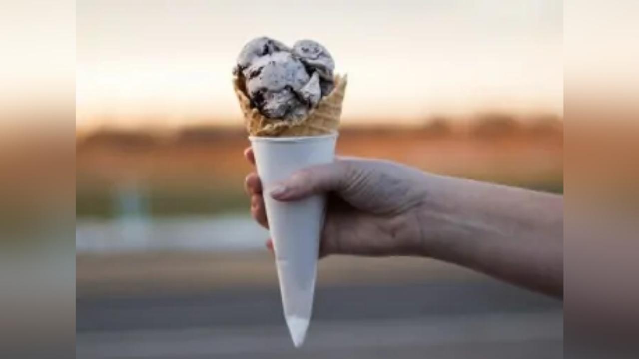 A person is holding an ice cream cone in their hand.