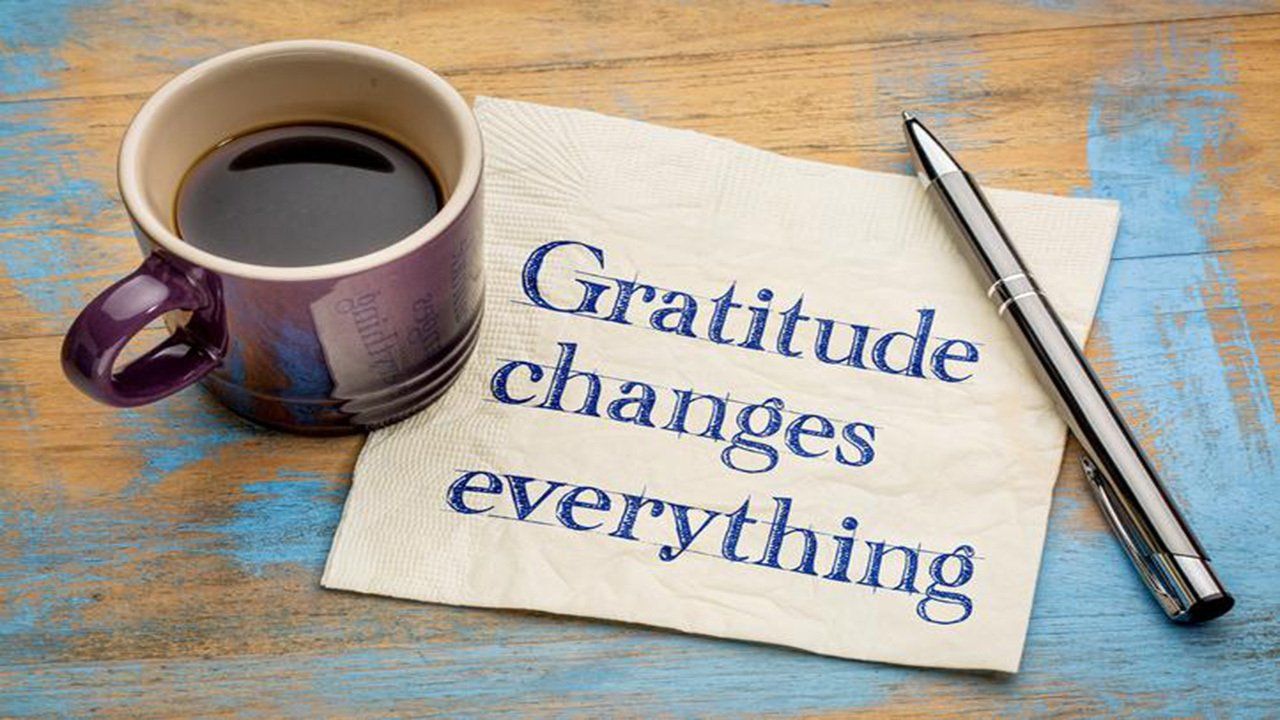 A cup of coffee and a napkin that says gratitude changes everything.