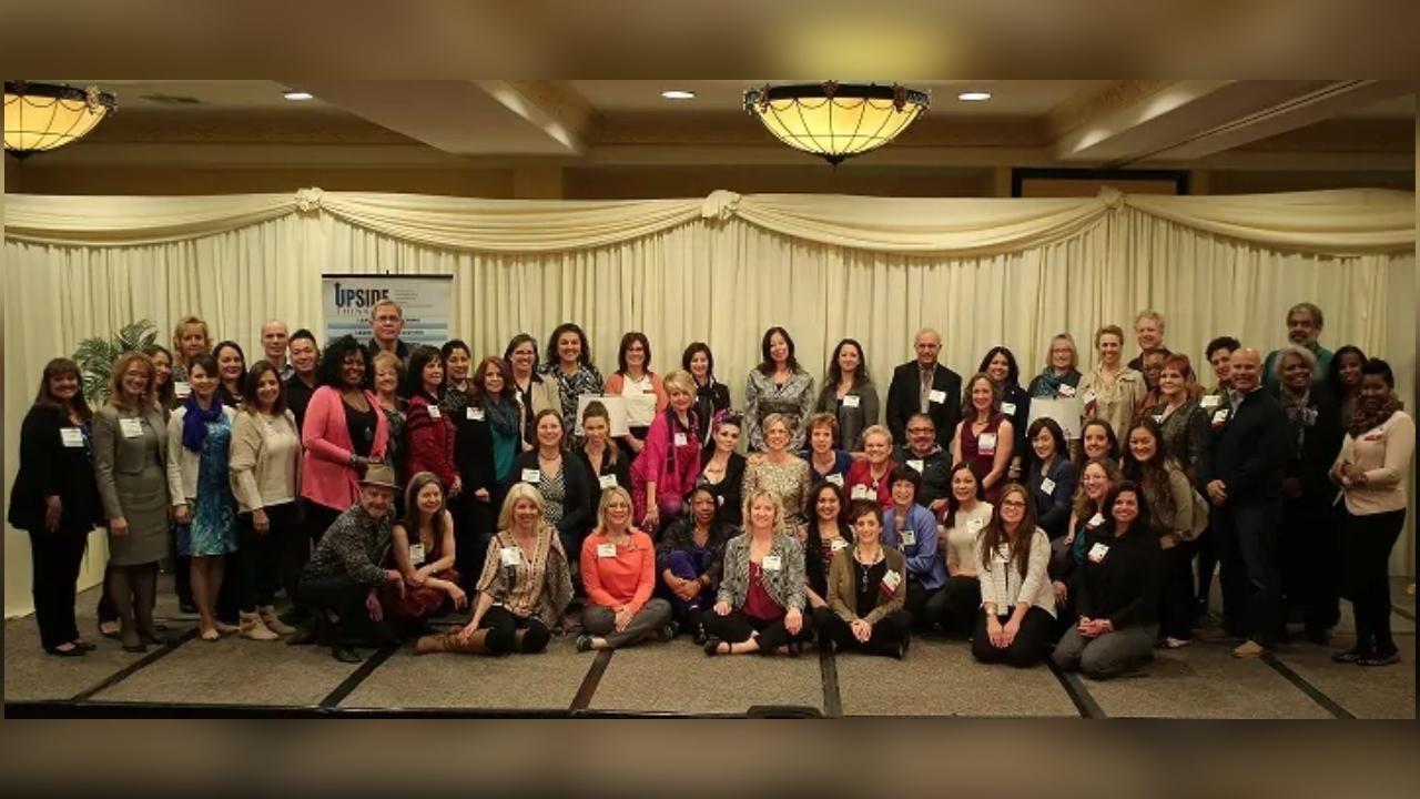 A large group of people are posing for a picture in a room.