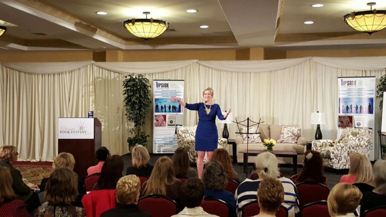 A woman is giving a presentation to a group of people in a room.