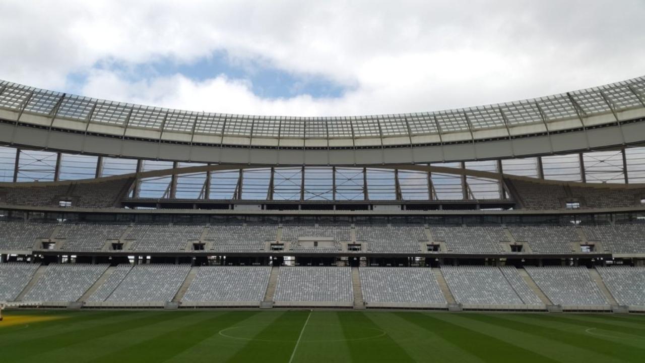 An empty soccer stadium with a blue sky in the background