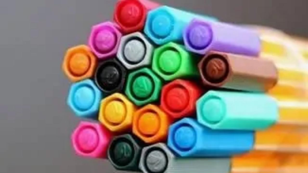 A bunch of colorful markers are stacked on top of each other.