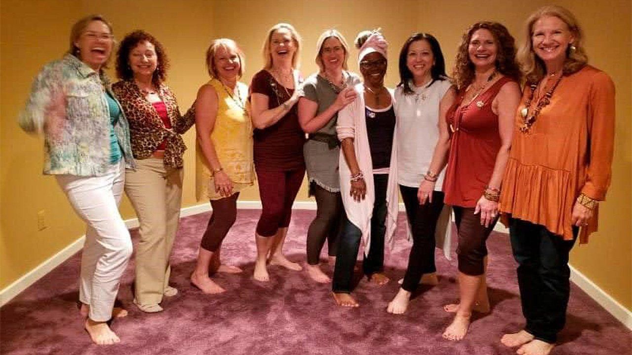 A group of women are posing for a picture in a room.