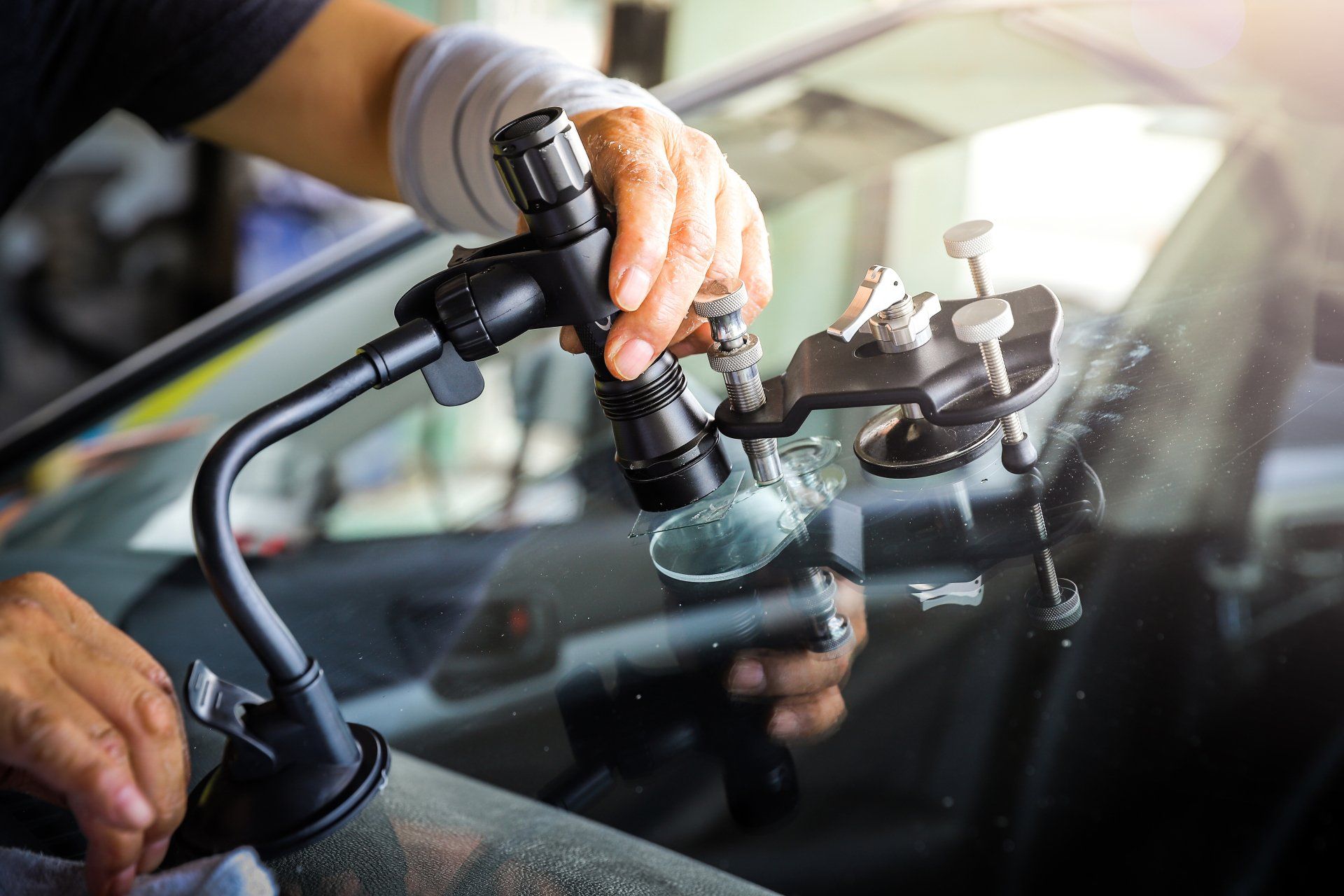 broken car glass being repaired using professional equipment