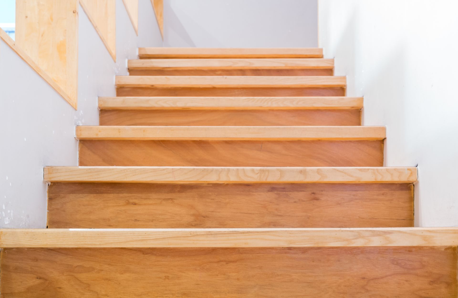 Wooden staircase with light-colored walls and natural light from above Wooden staircase with light-colored walls and natural light from above