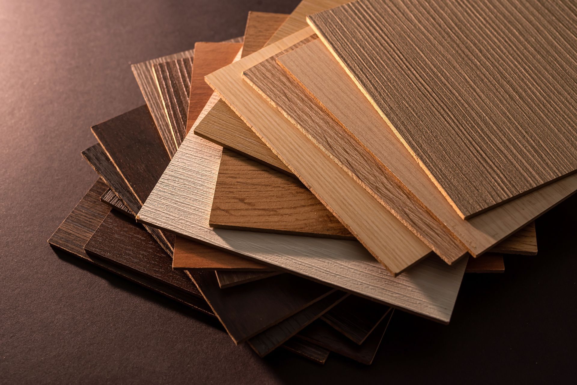 Stacked fabric swatches in neutral brown, tan, and black tones on a dark background Stacked fabric swatches in neutral brown, tan, and black tones on a dark background