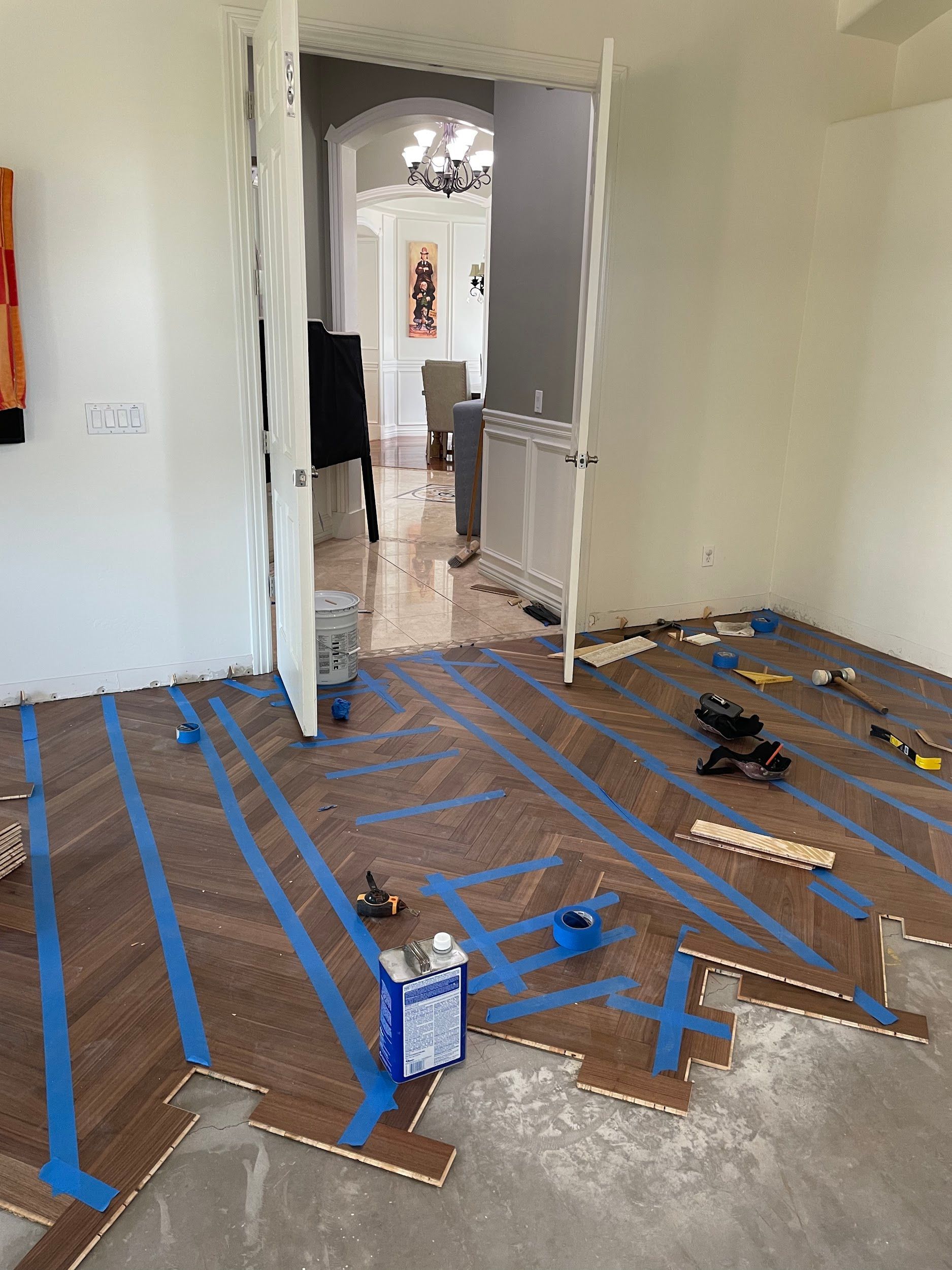 A room with a wooden floor and blue tape on it.