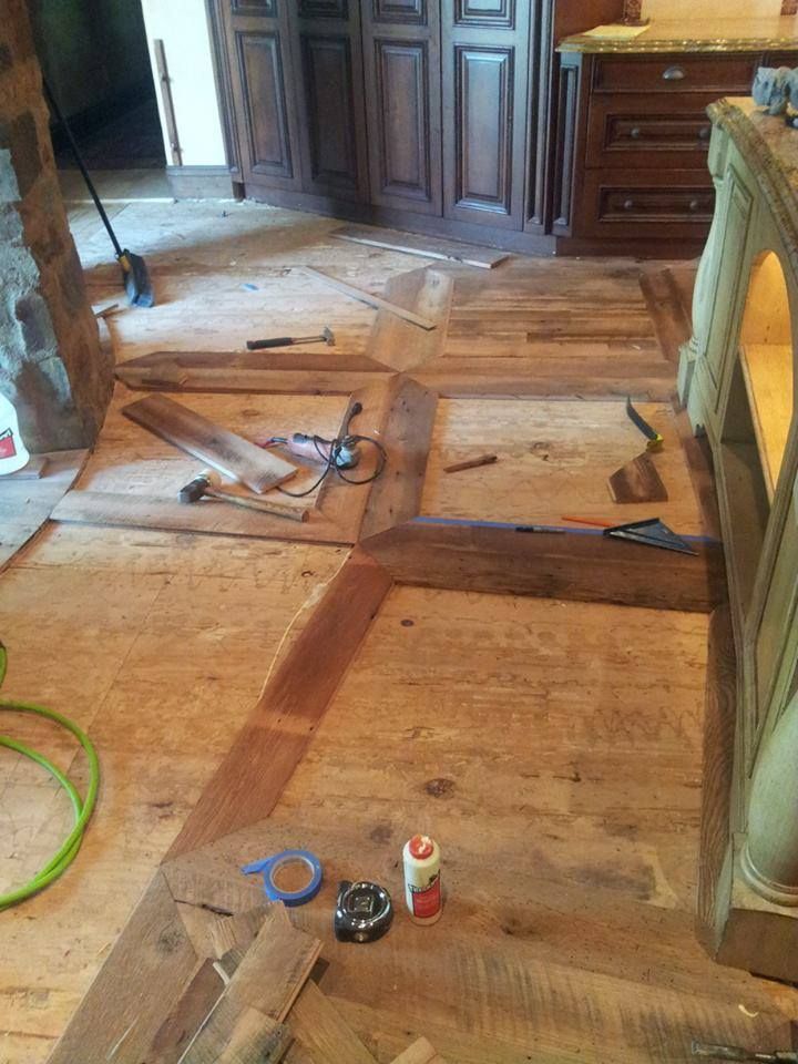 A wooden floor with tools and a bottle of glue on it.