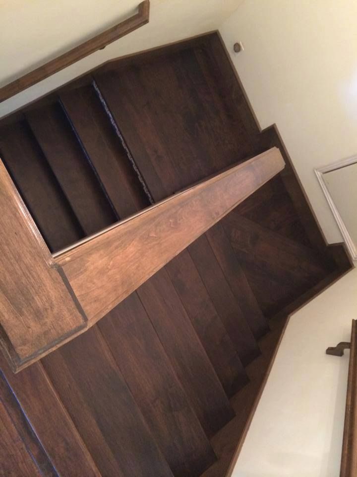 A set of wooden stairs with a wooden railing