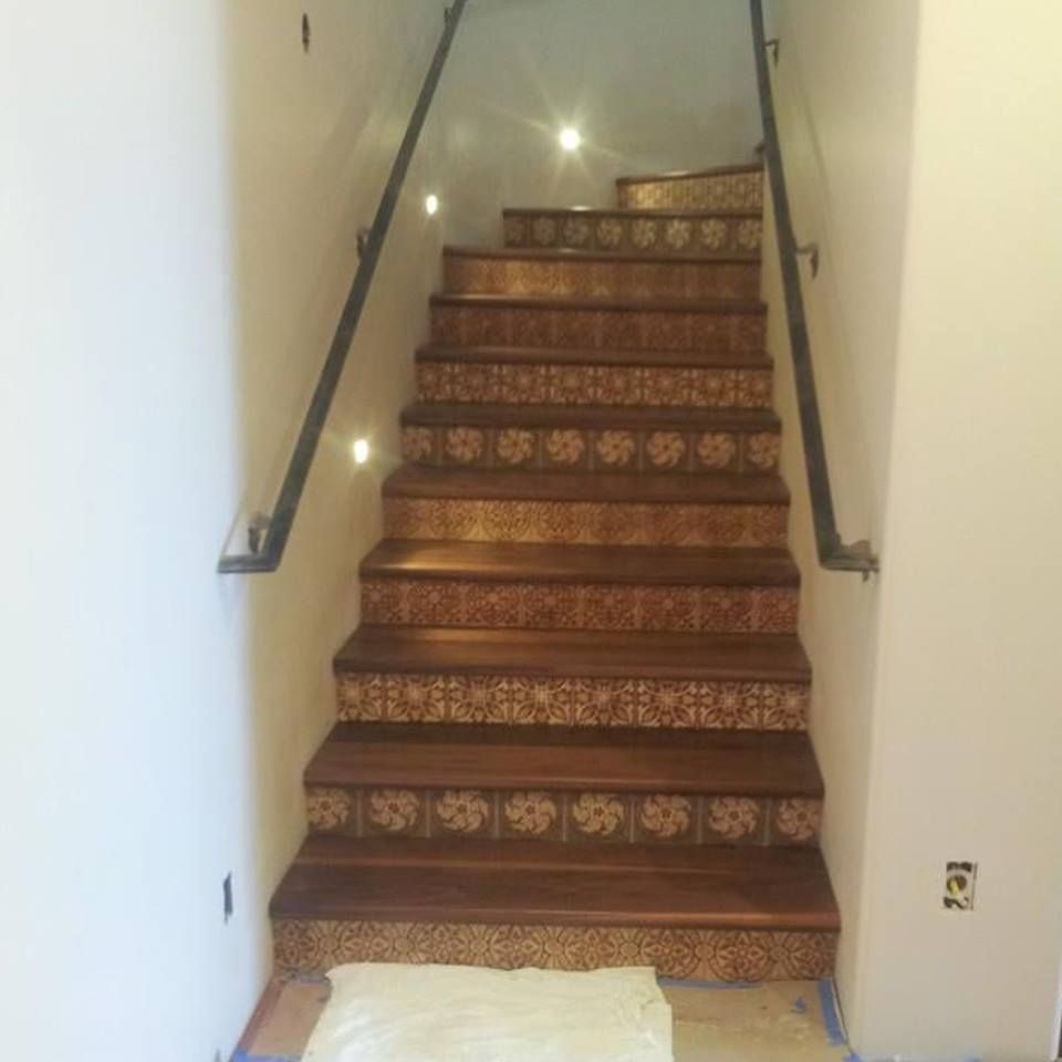 A set of tiled stairs with a glass railing