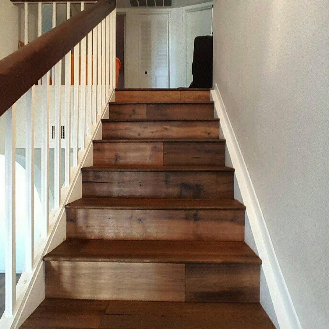 A set of wooden stairs with a white railing